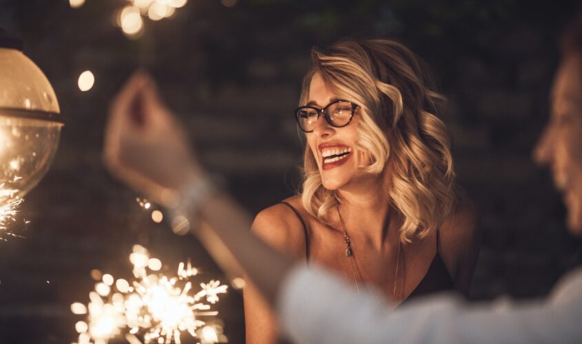 Woman laughing amid fireworks