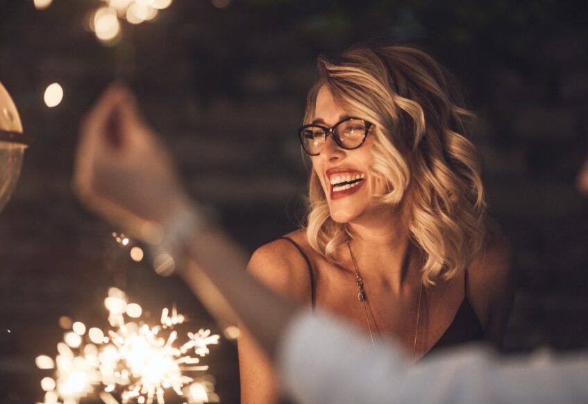 Woman laughing amid fireworks