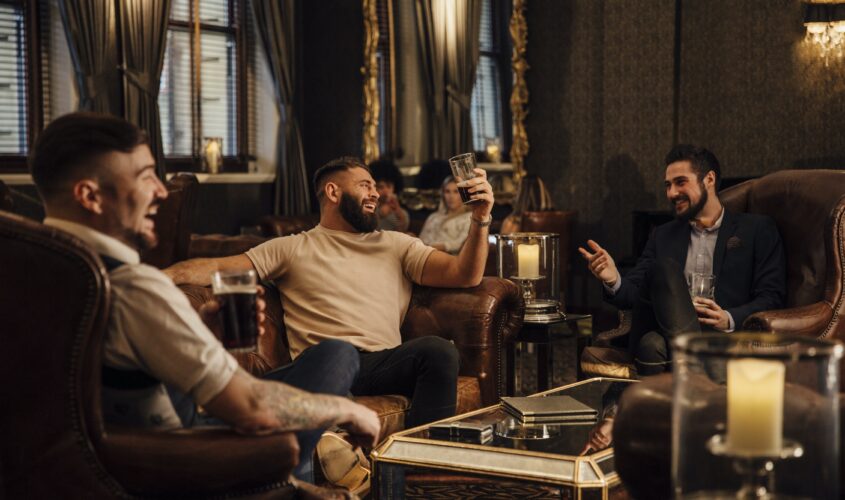 Men sitting in a lounge area drinking and laughing