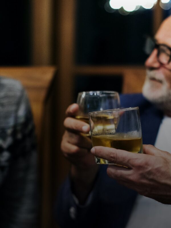 Men in a bar toasting with whiskey glasses