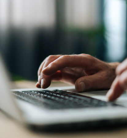 Person's hands typing on a laptop.